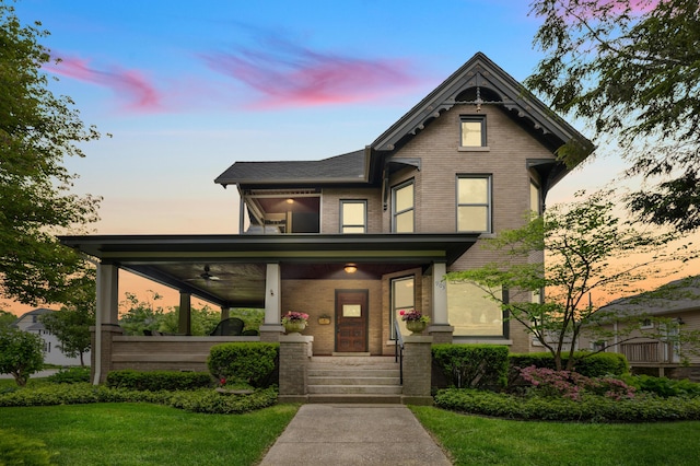 903 Lake Blvd, Saint Joseph, MI 49085 - victorian house featuring brick siding, ceiling fan, covered porch, a front yard, and a balcony