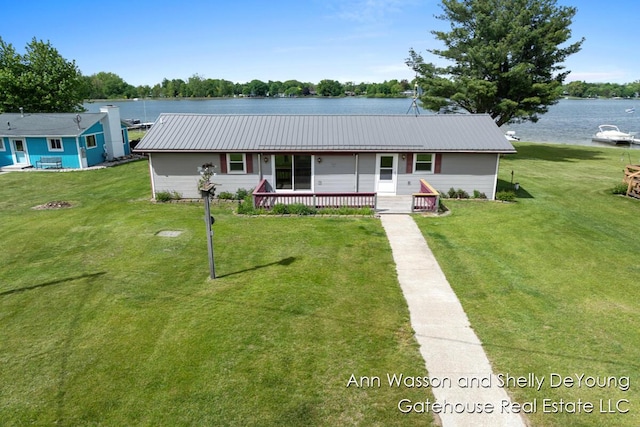 171 Dickerson Vw SW, Stanton, MI 48888 - view of front of house with a front lawn, metal roof, and a deck with water view
