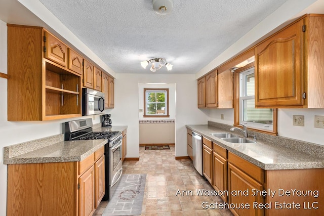 171 Dickerson Vw SW, Stanton, MI 48888 - kitchen featuring appliances with stainless steel finishes, a sink, baseboards, a textured ceiling, and brown cabinets