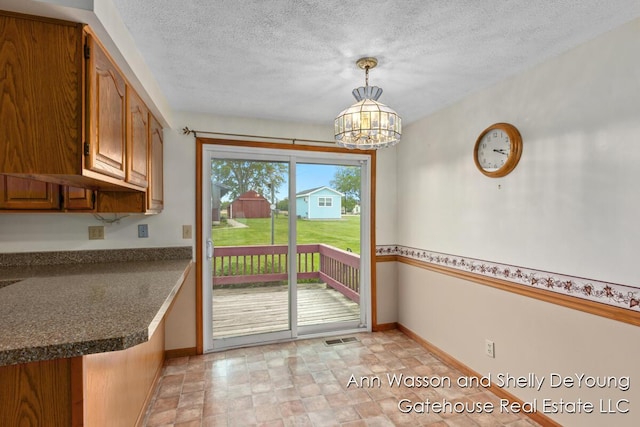 171 Dickerson Vw SW, Stanton, MI 48888 - doorway featuring stone finish flooring, a chandelier, baseboards, and a textured ceiling
