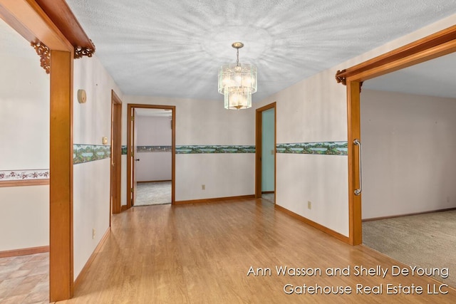 171 Dickerson Vw SW, Stanton, MI 48888 - unfurnished room featuring a chandelier, wood finished floors, and baseboards
