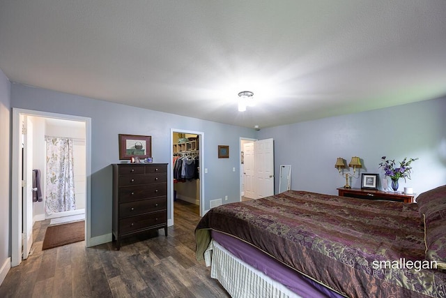 8637 Rainbows End Rd SE, Caledonia, MI 49316 - bedroom with dark wood-type flooring, a walk in closet, a closet, and connected bathroom