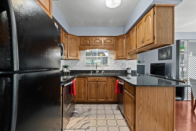 35519 Canyon Dr, Westland, MI 48186 - kitchen with stainless steel appliances, a sink, brown cabinetry, and a peninsula