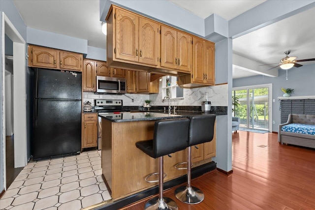35519 Canyon Dr, Westland, MI 48186 - kitchen featuring stainless steel appliances, a peninsula, a ceiling fan, decorative backsplash, and open floor plan