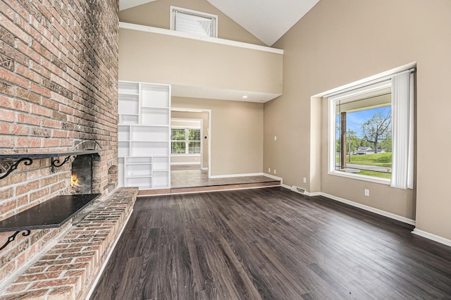 5643 Ivanrest Ave SW, Wyoming, MI 49418 - unfurnished living room with baseboards, dark wood-style floors, a fireplace, and high vaulted ceiling