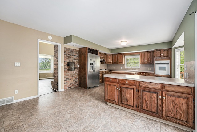 5643 Ivanrest Ave SW, Wyoming, MI 49418 - kitchen featuring oven, stainless steel fridge with ice dispenser, baseboards, light countertops, and plenty of natural light