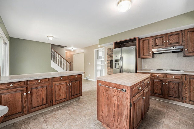 5643 Ivanrest Ave SW, Wyoming, MI 49418 - kitchen featuring stainless steel fridge with ice dispenser, under cabinet range hood, light countertops, white cooktop, and a kitchen island