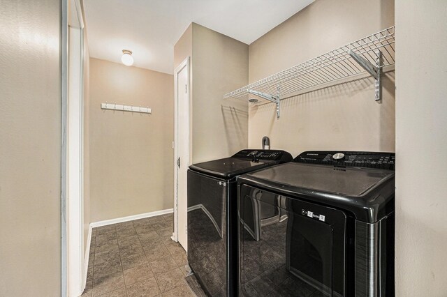 5643 Ivanrest Ave SW, Wyoming, MI 49418 - laundry room featuring washing machine and clothes dryer, tile patterned floors, and baseboards