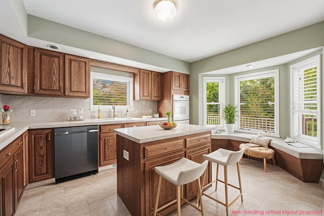 5643 Ivanrest Ave SW, Wyoming, MI 49418 - kitchen with stainless steel dishwasher, oven, a sink, light countertops, and backsplash
