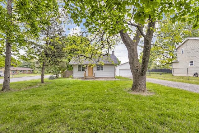 105 Renker Rd, Lansing, MI 48917 - view of front of house featuring entry steps, an outdoor structure, a detached garage, and a chimney