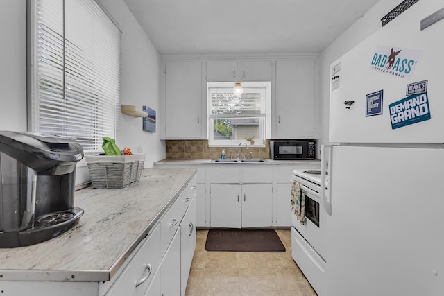 105 Renker Rd, Lansing, MI 48917 - kitchen with white appliances, a sink, light countertops, and white cabinetry