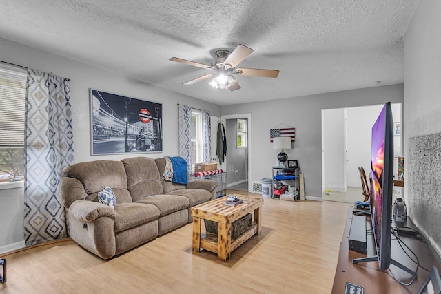 105 Renker Rd, Lansing, MI 48917 - living room featuring wood finished floors, a ceiling fan, a textured ceiling, and baseboards
