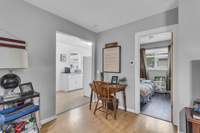 105 Renker Rd, Lansing, MI 48917 - dining area featuring wood finished floors, a textured ceiling, and baseboards