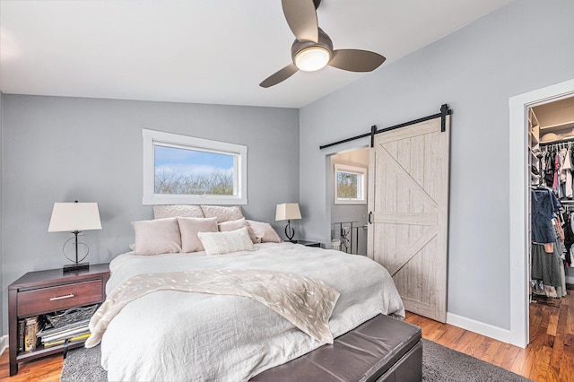 403 N Helen Ave, Rochester, MI 48307 - bedroom with a walk in closet, lofted ceiling, a barn door, a closet, and wood finished floors