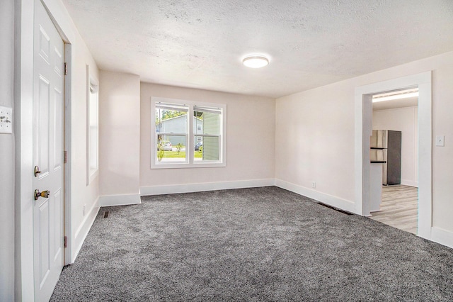 512 E Cass St, Schoolcraft, MI 49087 - unfurnished bedroom featuring carpet floors, a textured ceiling, and baseboards