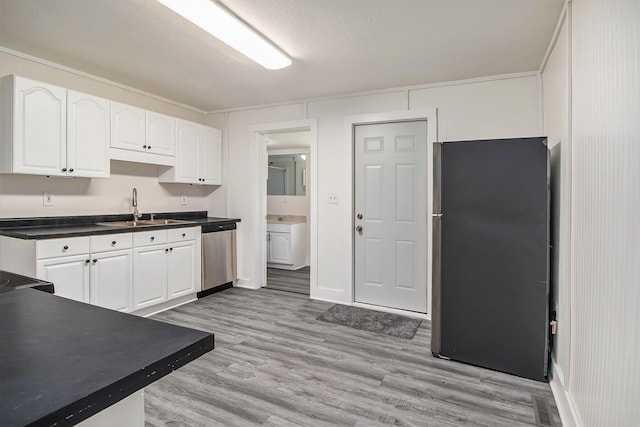 512 E Cass St, Schoolcraft, MI 49087 - kitchen with stainless steel appliances, a sink, white cabinets, dark countertops, and light wood finished floors
