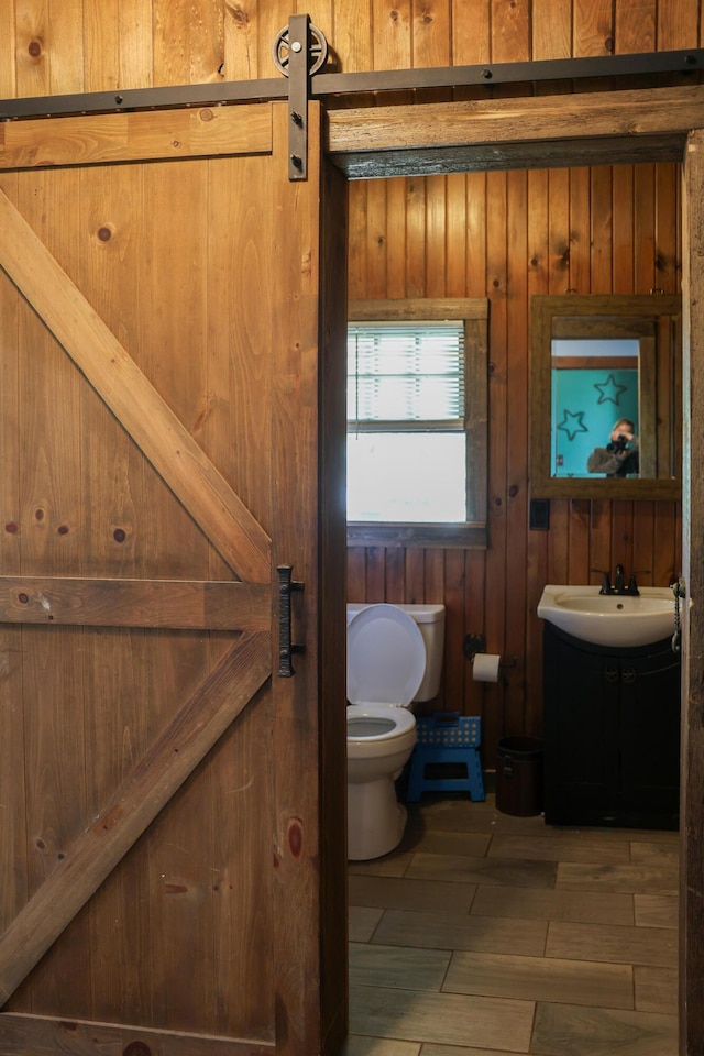 1041 W Arthur Rd, Rothbury, MI 49452 - half bathroom with toilet, vanity, and wooden walls