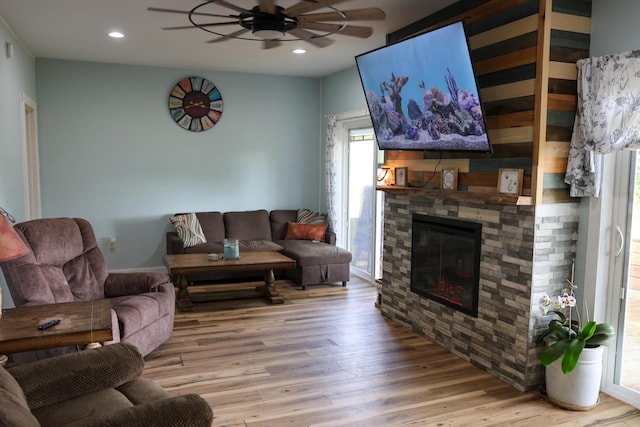 1041 W Arthur Rd, Rothbury, MI 49452 - living room featuring a ceiling fan, wood finished floors, plenty of natural light, a stone fireplace, and recessed lighting