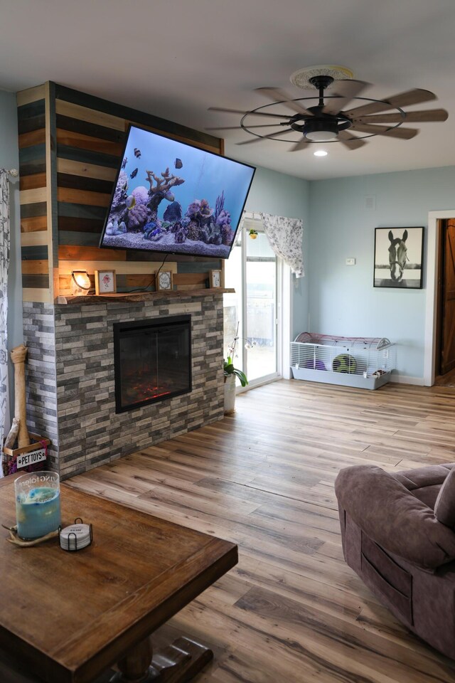 1041 W Arthur Rd, Rothbury, MI 49452 - living room featuring ceiling fan, wood finished floors, a stone fireplace, and recessed lighting