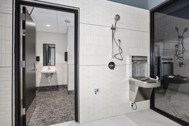 144 Oakes St SW Unit 1903, Grand Rapids, MI 49503 - full bathroom featuring tile walls, a stall shower, tile patterned floors, recessed lighting, and a sink