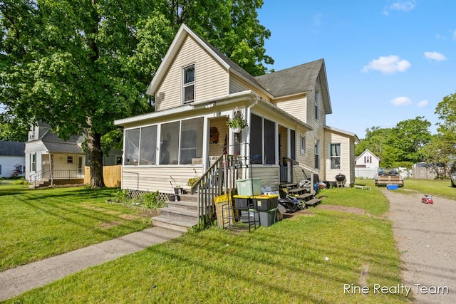 717 Pleasant St, Belding, MI 48809 - view of front of home featuring a sunroom and a front yard