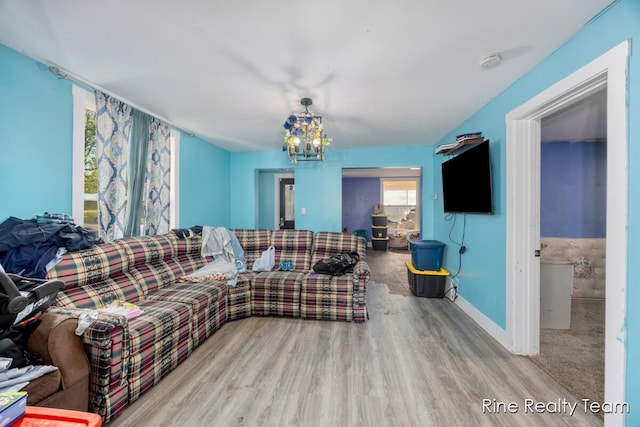 717 Pleasant St, Belding, MI 48809 - living room featuring wood finished floors, baseboards, and a chandelier
