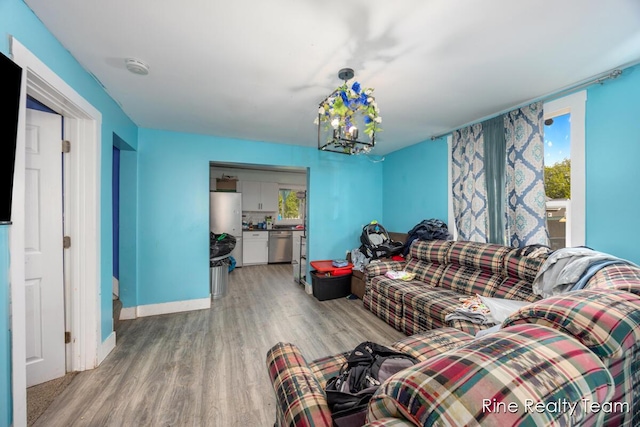 717 Pleasant St, Belding, MI 48809 - living area featuring light wood-style flooring, plenty of natural light, baseboards, and a chandelier