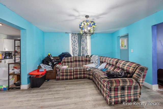 717 Pleasant St, Belding, MI 48809 - living room with wood finished floors, a chandelier, and baseboards