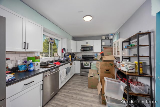 717 Pleasant St, Belding, MI 48809 - kitchen featuring stainless steel appliances, a sink, backsplash, and white cabinets