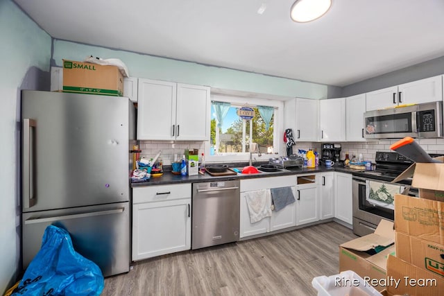 717 Pleasant St, Belding, MI 48809 - kitchen featuring stainless steel appliances, backsplash, and white cabinets