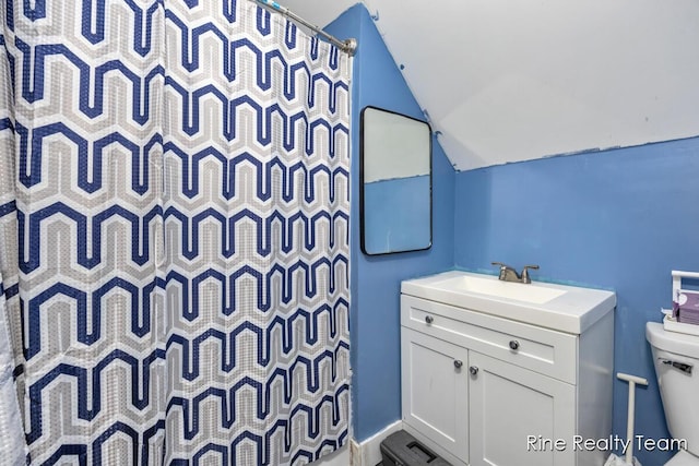 717 Pleasant St, Belding, MI 48809 - bathroom with lofted ceiling, toilet, vanity, and a shower with curtain