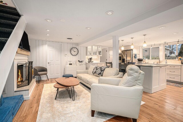 17437 Lakeview Dr Unit 100, Vandalia, MI 49095 - living room featuring a warm lit fireplace, light wood-type flooring, and recessed lighting
