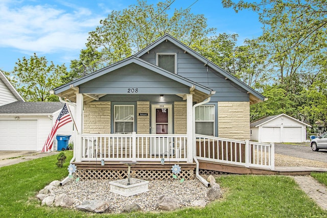 208 Nelson Ave, Kalamazoo, MI 49006 - view of front of house featuring covered porch, a detached garage, a front lawn, and an outbuilding