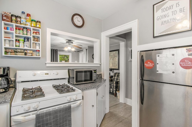 208 Nelson Ave, Kalamazoo, MI 49006 - kitchen featuring appliances with stainless steel finishes, white cabinets, ceiling fan, and light wood-style flooring