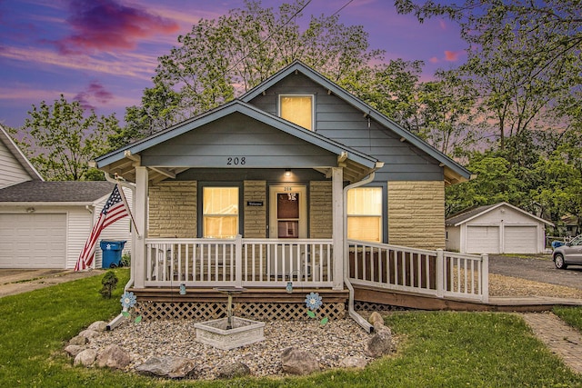 208 Nelson Ave, Kalamazoo, MI 49006 - view of front facade with covered porch, a garage, a lawn, and an outbuilding