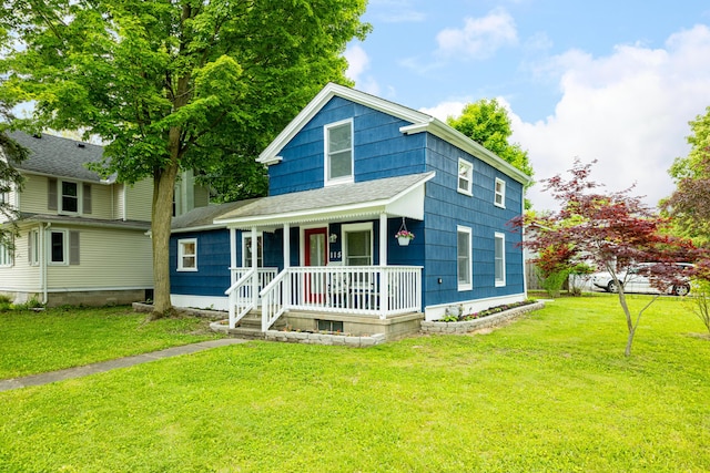 115 Mckinley St, Chelsea, MI 48118 - american foursquare style home with a porch, a front lawn, and a shingled roof