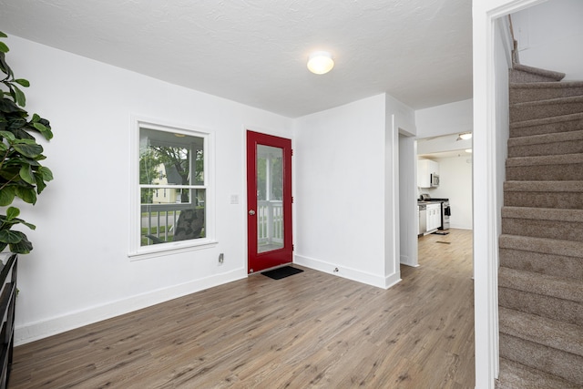115 Mckinley St, Chelsea, MI 48118 - foyer entrance featuring stairway, wood finished floors, and baseboards