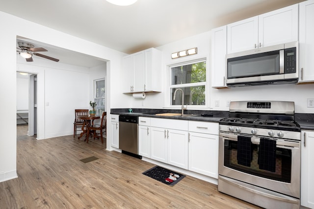 115 Mckinley St, Chelsea, MI 48118 - kitchen with stainless steel appliances, a sink, light wood-style floors, and dark countertops