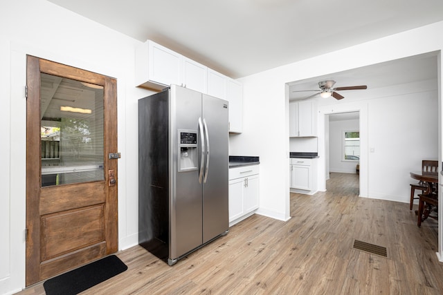 115 Mckinley St, Chelsea, MI 48118 - kitchen with stainless steel fridge, white cabinets, light wood-type flooring, and dark countertops