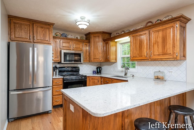 7153 Keystone Ct, Jenison, MI 49428 - kitchen featuring stainless steel appliances, a sink, a peninsula, and brown cabinetry