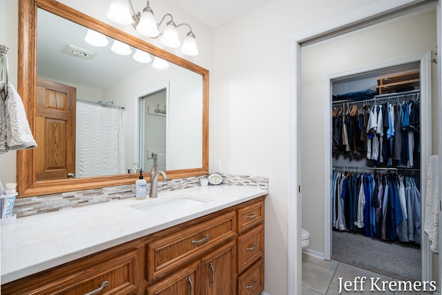 7153 Keystone Ct, Jenison, MI 49428 - full bath featuring vanity, toilet, tasteful backsplash, and tile patterned floors