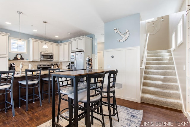 807 Lake St Unit 7, Saugatuck, MI 49453 - dining room with dark wood-type flooring, stairway, recessed lighting, and wainscoting