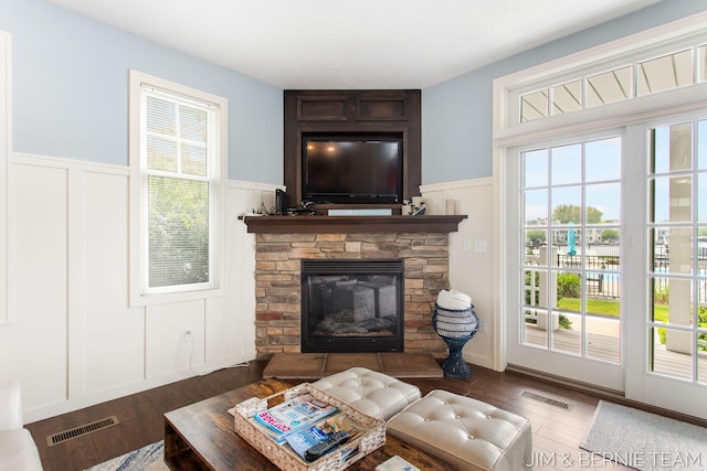 807 Lake St Unit 7, Saugatuck, MI 49453 - living room featuring a decorative wall, wood finished floors, wainscoting, a fireplace, and healthy amount of natural light