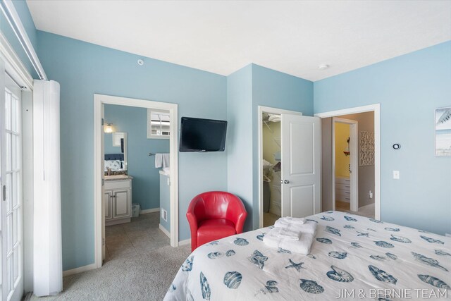 807 Lake St Unit 7, Saugatuck, MI 49453 - bedroom featuring light carpet, baseboards, ensuite bath, and a sink
