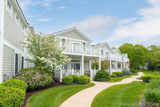 807 Lake St Unit 7, Saugatuck, MI 49453 - view of front facade featuring a balcony, a porch, and a front lawn