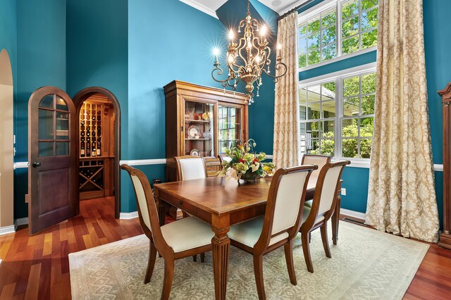 6461 E Bay Ln, Richland, MI 49083 - dining area featuring a towering ceiling, a chandelier, wood finished floors, and baseboards