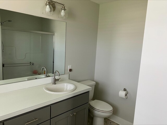 3699 Teton Dr, Hudsonville, MI 49426 - full bathroom featuring a shower with shower door, vanity, toilet, and baseboards