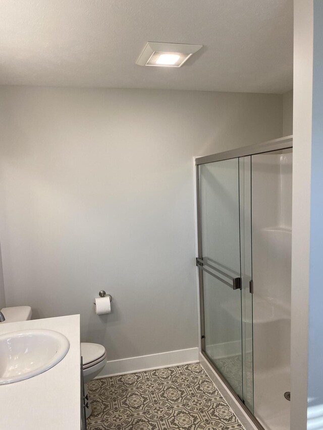 3699 Teton Dr, Hudsonville, MI 49426 - full bath featuring toilet, a stall shower, baseboards, vanity, and tile patterned floors