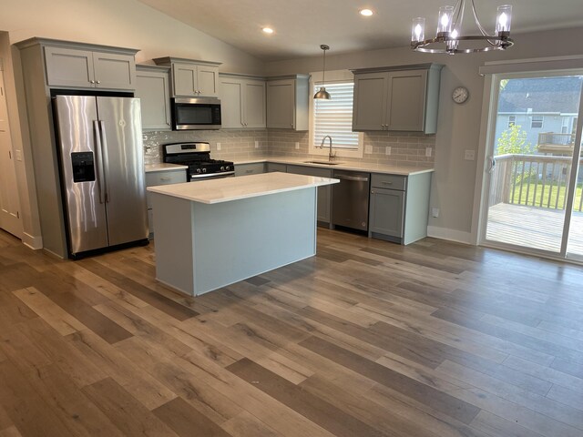 3699 Teton Dr, Hudsonville, MI 49426 - kitchen with stainless steel appliances, gray cabinets, vaulted ceiling, a chandelier, and backsplash