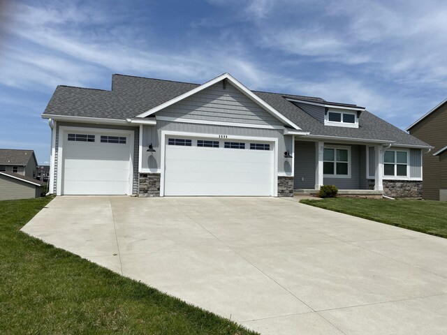 3699 Teton Dr, Hudsonville, MI 49426 - craftsman house with stone siding, a garage, concrete driveway, and roof with shingles